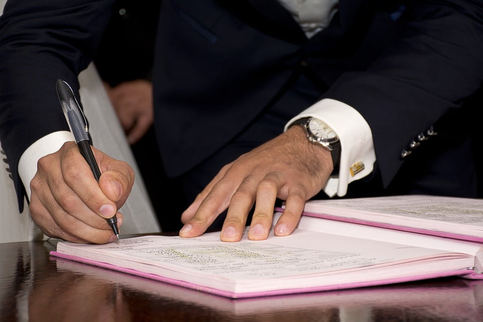 close up of man signing a document