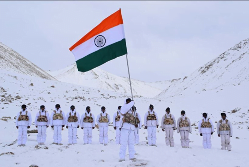 indian soldiers with national flag on snow clad mountain