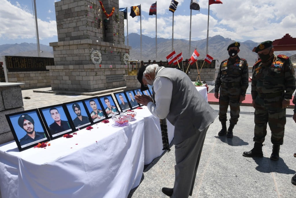 PM bowing down in front of slain soldiers photo